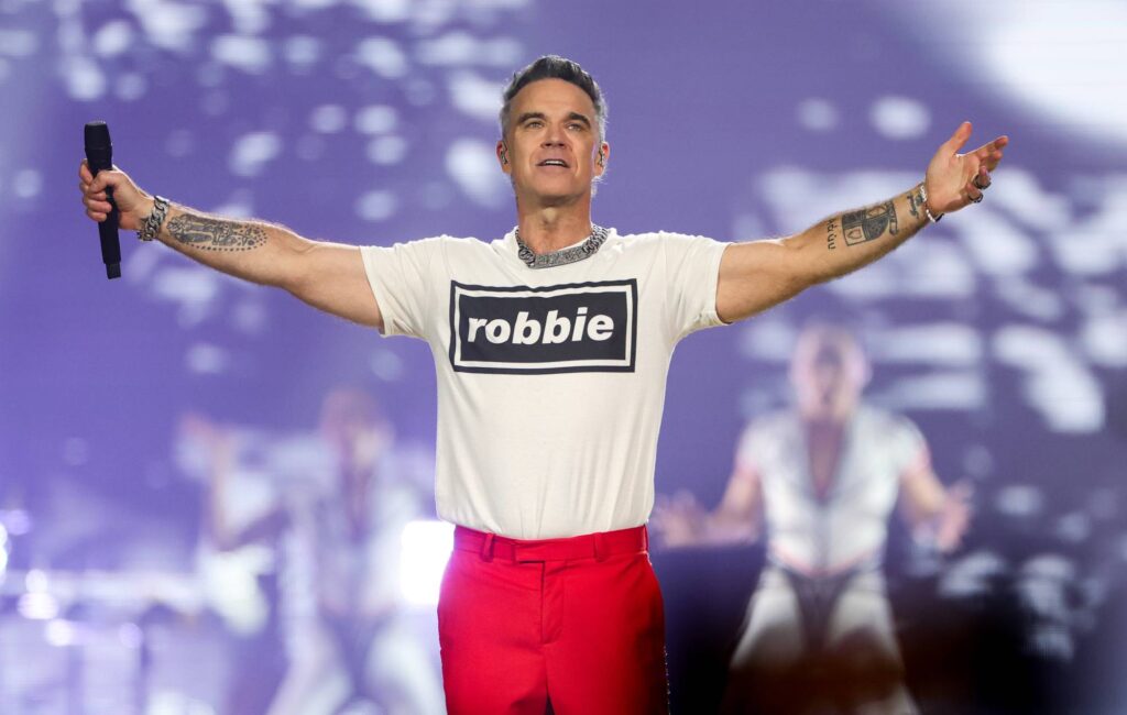 Guarda Robbie Williams sorprendere i fan suonando "Angels" per le strade di Siviglia