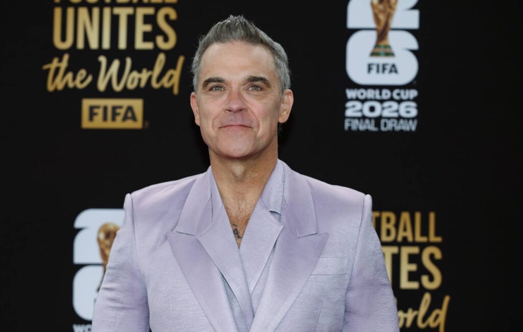 Robbie Williams risponde alle affermazioni che la cocaina gli è caduta dalla faccia sul microfono durante l'intervista televisiva della Coppa del Mondo